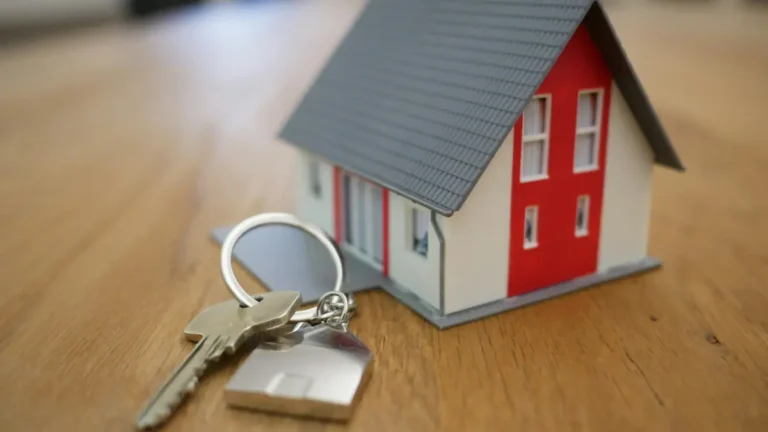 First Home buying concept showing house keys and a model home on a table