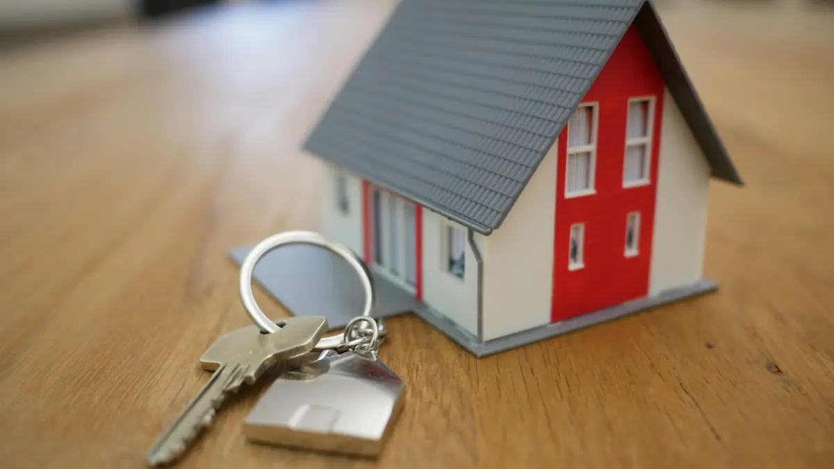 First Home buying concept showing house keys and a model home on a table