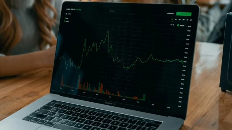 NASDAQ stock market price chart displayed on a laptop screen showing real time trading movement
