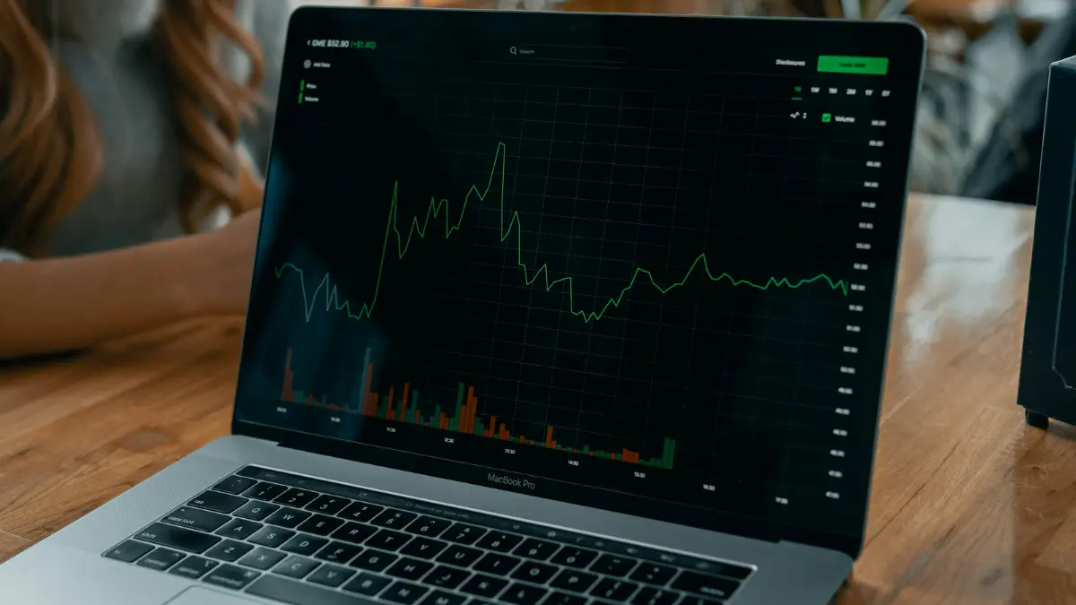 NASDAQ stock market price chart displayed on a laptop screen showing real time trading movement