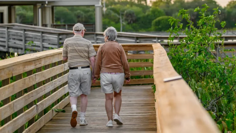 Retirement Savings planning concept showing a retired couple walking confidently toward the future