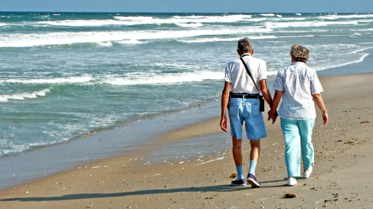 Roth IRA tax-free retirement lifestyle showing a retired couple walking peacefully on the beach after years of smart Roth IRA planning