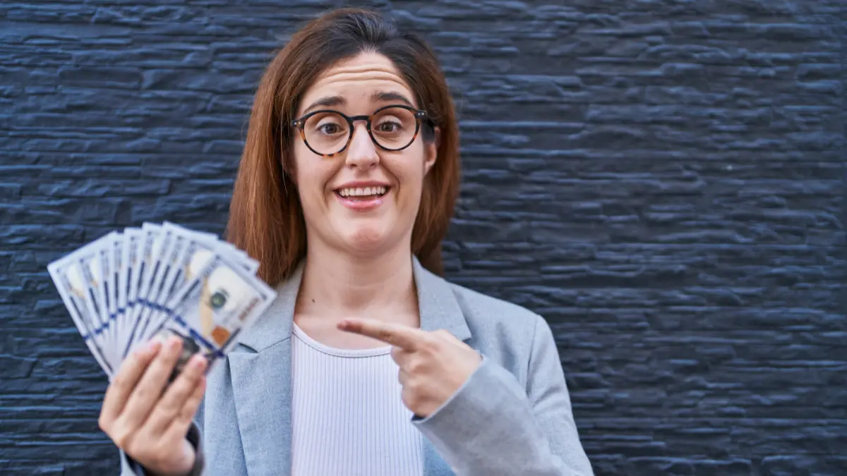 woman holding cash representing payday loan quick money promise 2026 warning article