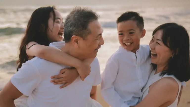 Happy family enjoying beach vacation representing financial security with Care Health Insurance coverage