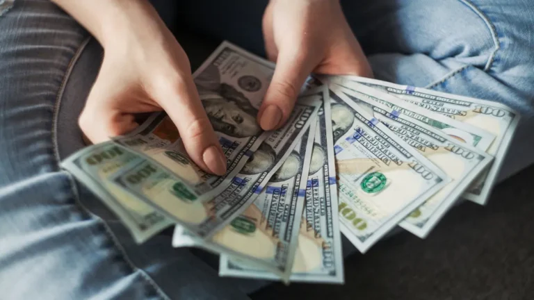 Personal Loan cash disbursement showing borrower holding US dollar bills after loan approval