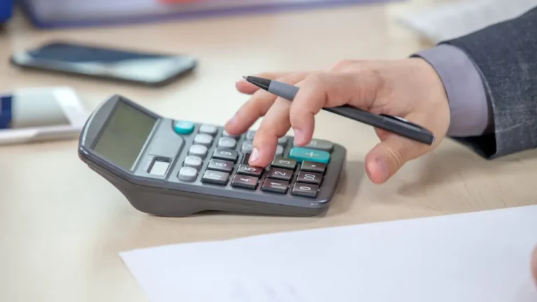 VAT calculation concept showing a person calculating VAT using a calculator
