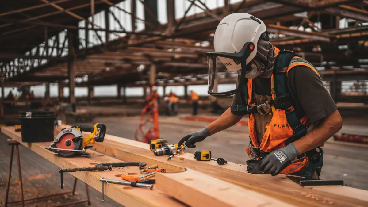 Construction worker using tools at a job site representing Workers' Compensation workplace injury coverage