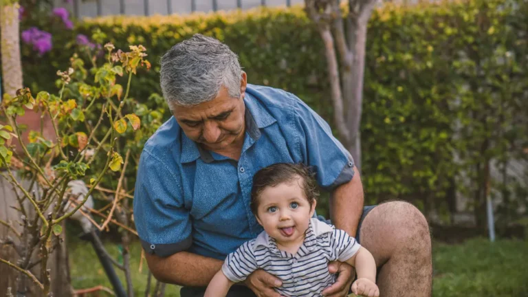 Grandfather holding baby symbolizing long-term retirement savings using a 401(k) Calculator