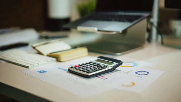 Capital Gains Tax Calculator concept showing financial calculator on investment charts used to estimate capital gains taxes in 2026