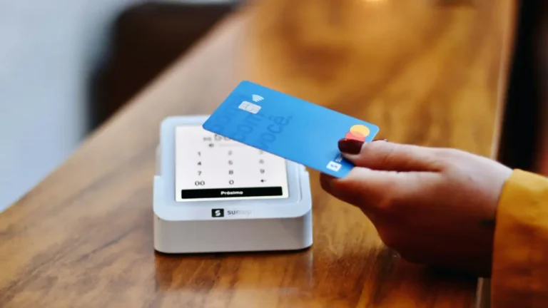 Credit Card Payoff Calculator concept showing a person making a credit card payment on a card reader