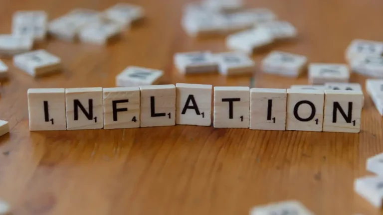 Inflation Calculator concept image showing wooden blocks spelling inflation representing rising prices and reduced purchasing power