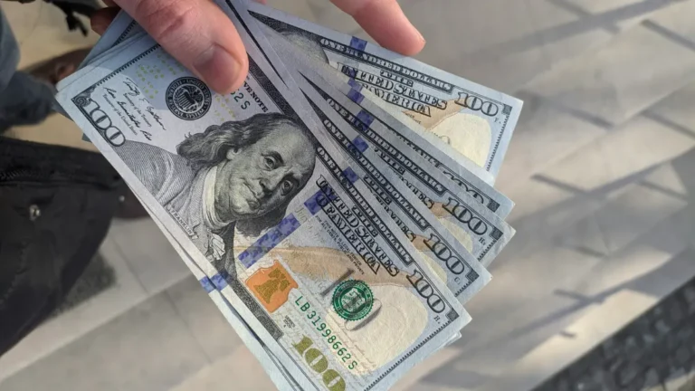 Loan Calculator concept image showing $100 bills representing loan amount monthly payment and interest cost