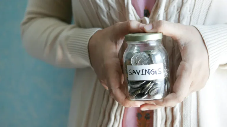 Savings Calculator concept showing hands holding a jar filled with coins labeled savings representing money growth